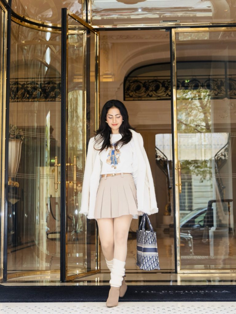  White Graphic Tee + Beige Pleated Mini Skirt + Cream Faux-fur Coat