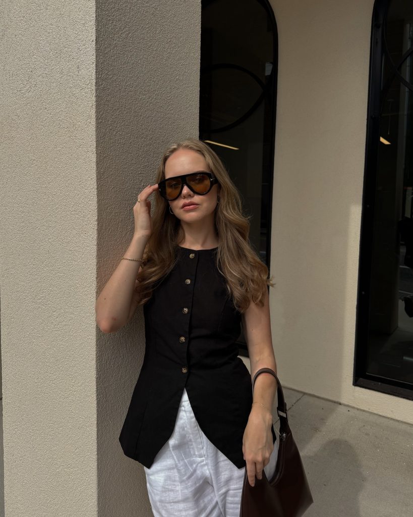 Black Button-Down Vest + White Linen Pants + Oversized Sunglasses