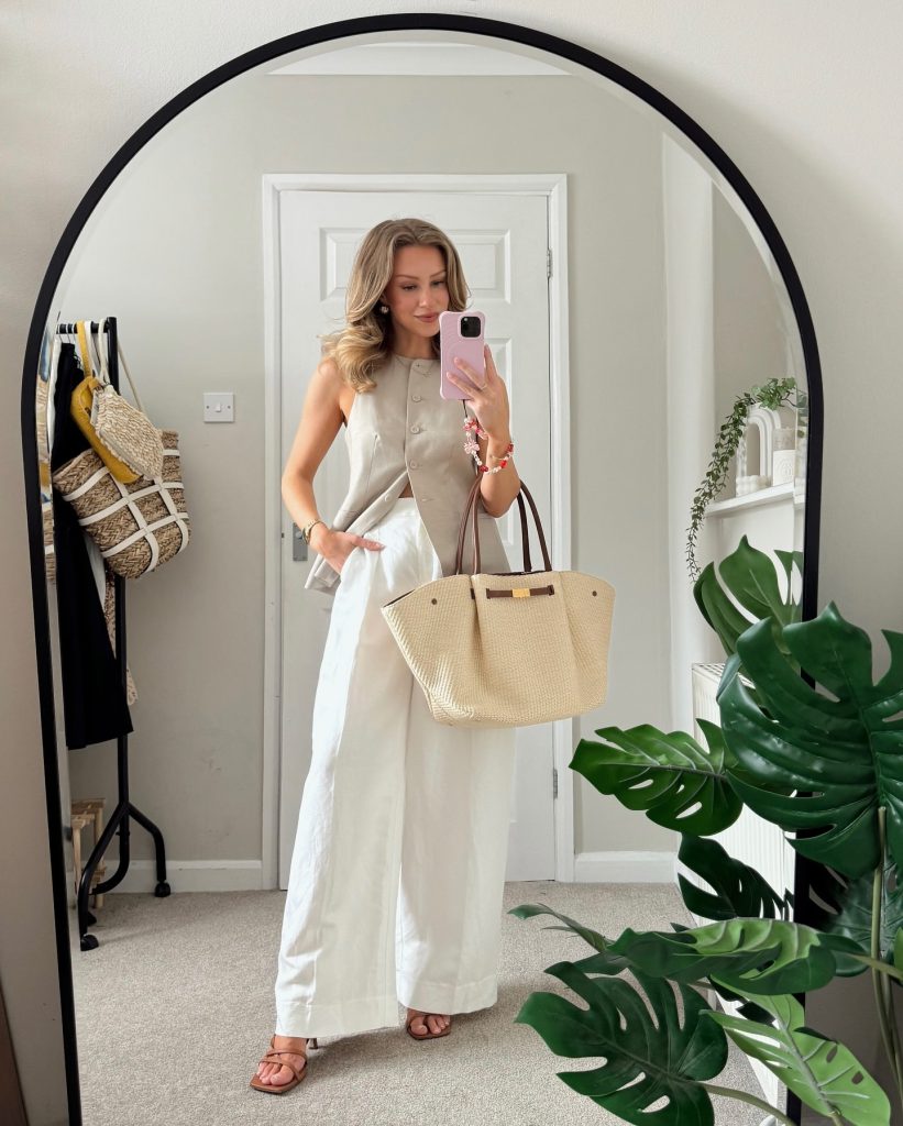 Beige Button-Up Vest + Large Straw Tote + White Wide-Leg Trousers