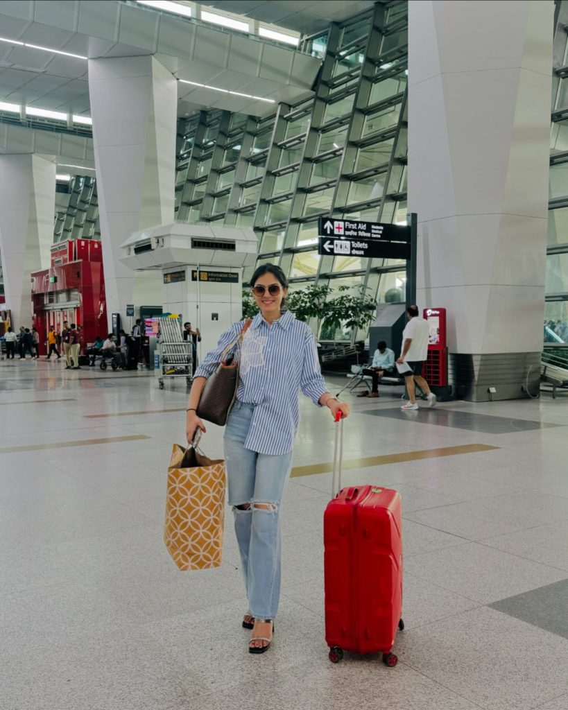 Blue Striped Button-Down + Distressed Jeans + Red Suitcase